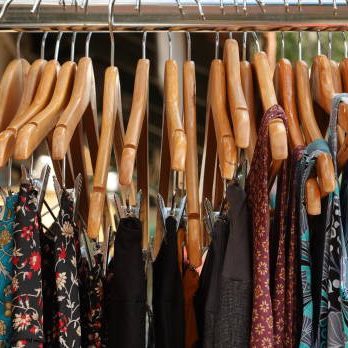 Assorted Clothes On Wooden Hangers, Close-Up Of A Garment Rack In Natural Light